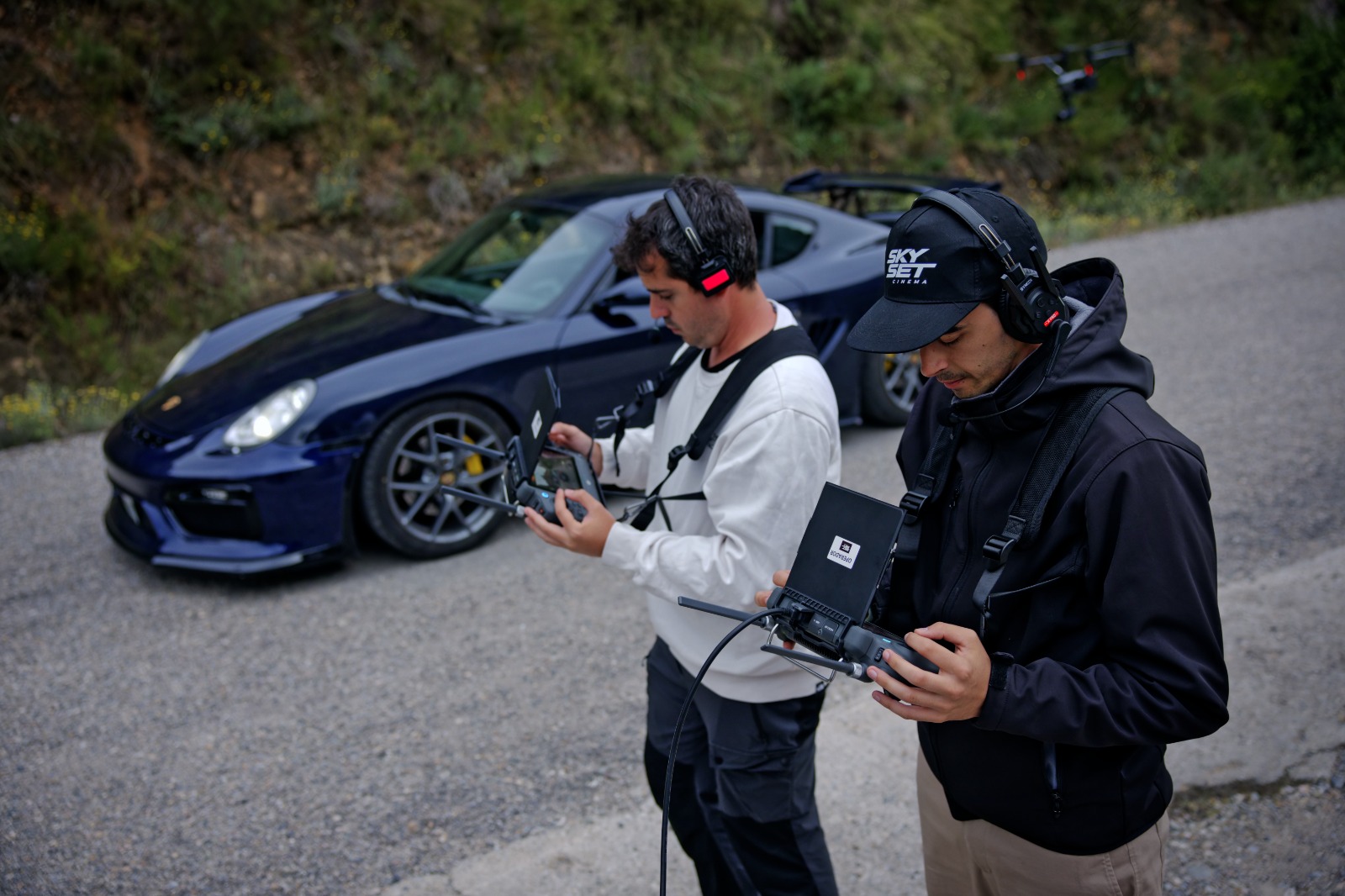 Francisco Zamora y Alex Viñals operando el DJI Inspire frente a un Porsche Cayman GT4