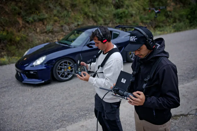 Francisco Zamora y Alex Viñals operando el Inspire frente a un Porsche